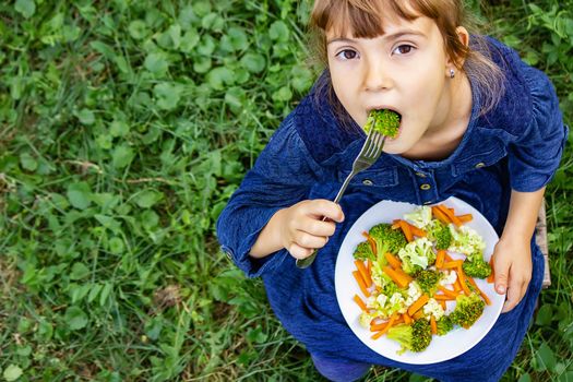 child eats vegetables. Summer photo. Selective focus nature