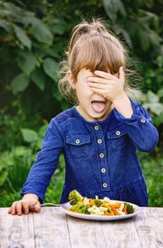 child eats vegetables. Summer photo. Selective focus nature