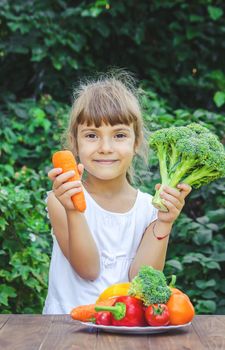 The child eats vegetables in summer. Selective focus. People.