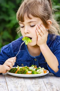 child eats vegetables. Summer photo. Selective focus nature