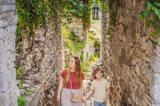 Mom and son tourists walks through the old town of Bar in Montenegro. Happy tourist walks in the mountains. Suburbs of the city of Bar, Montenegro, Balkans. Beautiful nature and landscape.
