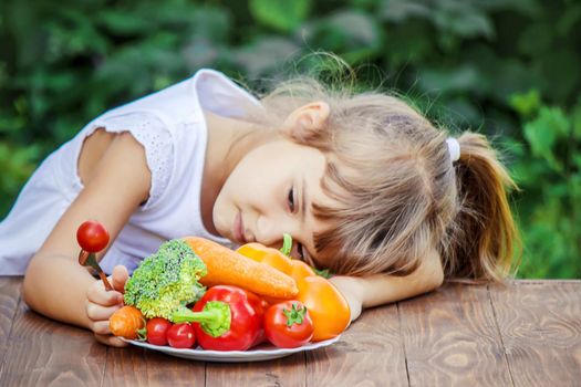 child eats vegetables. Summer photo. Selective focus nature