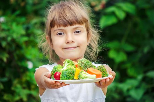 child eats vegetables. Summer photo. Selective focus nature