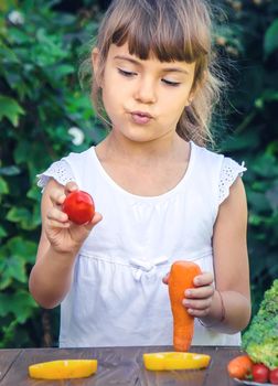 The child eats vegetables in summer. Selective focus. People.