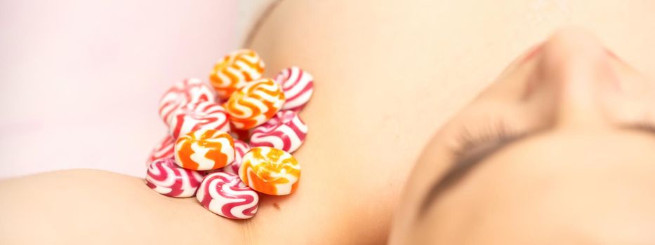 Waxing, depilation armpit concept. Colored round candies lying down on the female armpit, close up