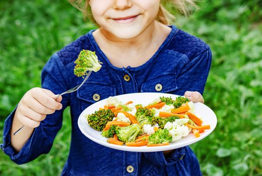 child eats vegetables. Summer photo. Selective focus nature