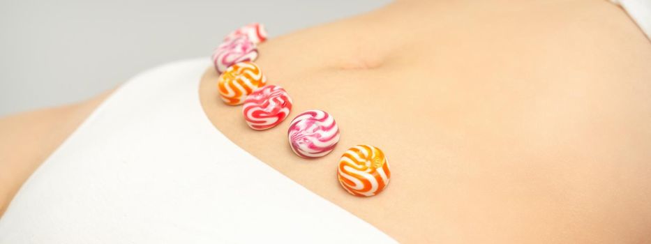 Concept of intimate depilation, intimate waxing, depilation. Round candies lying down in a row on the female bikini zone, intimate area, close up