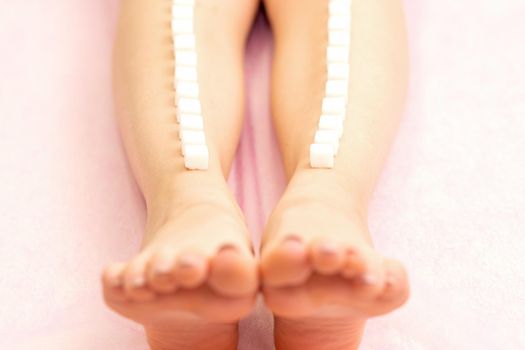 The concept of epilation, waxing. Sugar cubes lie down in a row on the naked white female leg