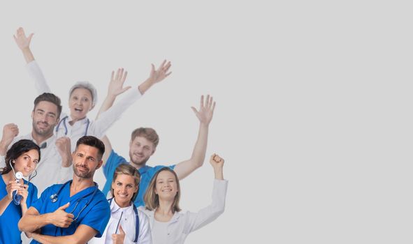 Group of happy smiling doctors raising their arms on gray background with copy space for text