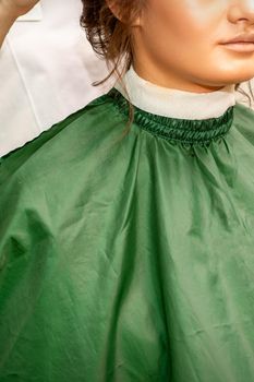 Hairstyling bride. A female hairdresser makes styling hair for the beautiful young caucasian woman in a beauty salon