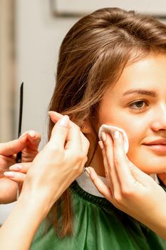 Makeup artist and hairdresser prepare the bride making hairstyle and makeup in a beauty salon