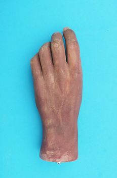 Part of the old artificial hand on blue background top view.