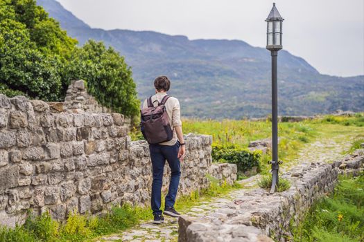 Man tourist walks through the old town of Bar in Montenegro. Happy tourist walks in the mountains. Suburbs of the city of Bar, Montenegro, Balkans. Beautiful nature and landscape.