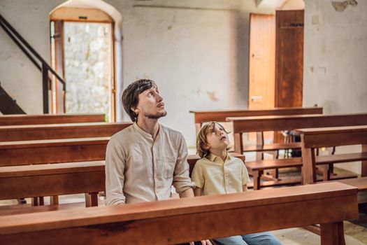 Christian dad tells his son Bible stories about Jesus sitting in kirk. Faith, religious education, modern church, father day, fatherly responsibilities, father influence on formation of son worldview.