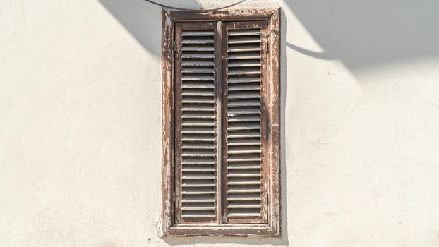 Closed wooden window shutters on a white wall, background. High quality photo