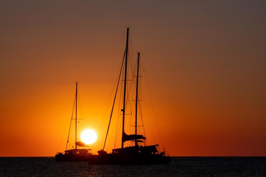 Two sailboats silhouetted by the sunset in the Mediterranean Sea