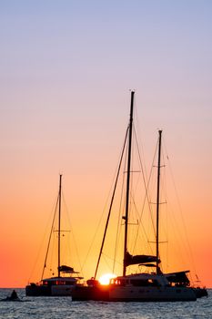 Two sailboats silhouetted by the sunset in the Mediterranean Sea