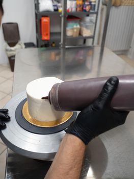 decorating a frosted cake with chocolate and nutella