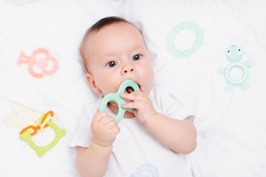 A baby with a teether on a white background . Teething. Children's article. Copy space