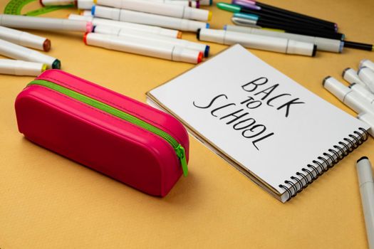 Back to school is written in black marker on a white notebook. School background. School supplies are prepared for school.