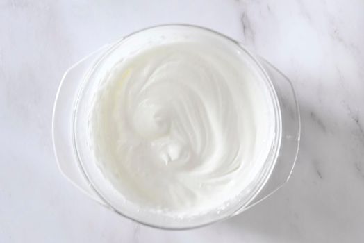 step of Cooking icing for cookies, powdered sugar with whites in a bowl, homemade holiday baked good. High quality photo