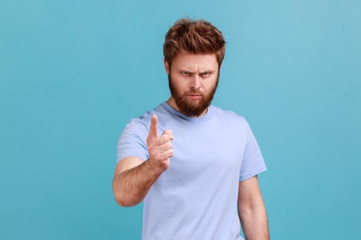 Portrait of strict serious young bearded man warning of mistake, looking at camera with admonishing finger and alarming, giving advice. Indoor studio shot isolated on blue background.