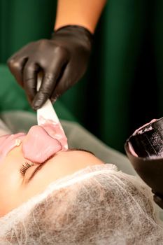 Beautiful young caucasian woman receiving an alginic mask to the face in beauty salon. Facial skin treatment