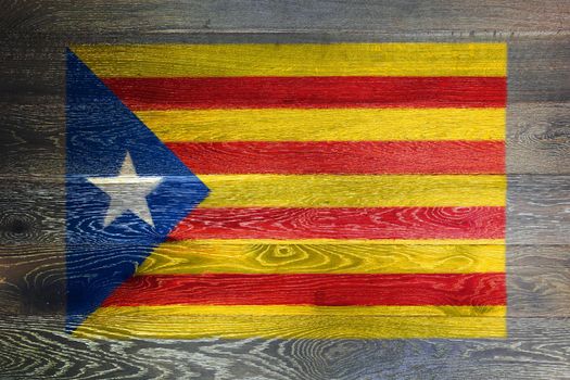 A Catalonia independence flag on rustic old wood surface background red yellow blue white star Estelada