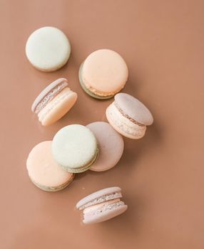 Pastry, bakery and branding concept - French macaroons on cream beige background, parisian chic cafe dessert, sweet food and cake macaron for luxury confectionery brand, holiday backdrop design