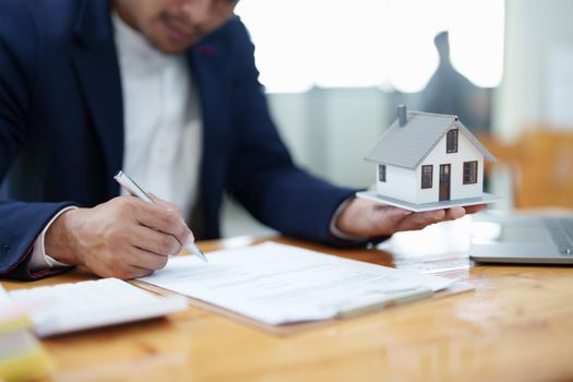 Guarantee, Mortgage, agreement, contract, Signing, Male client holding pen to reading agreement document to sign land loan with real estate agent or bank officer.