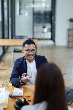 Portrait of a male lawyer with a smiling face advising clients on legal matters to fight a lawsuit against a defendant in court.