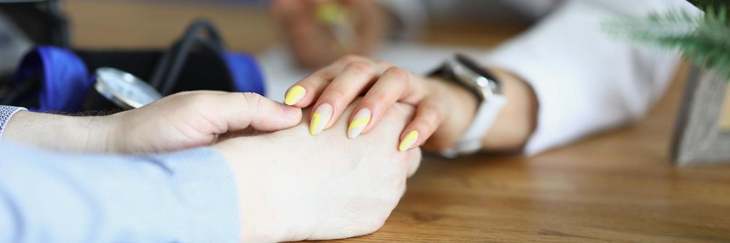 The doctor calms the patient, hands on the table close-up, blurry. Calmness during illness, oncology diagnostics