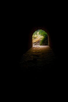 dark tunnel with light and colors at the end
