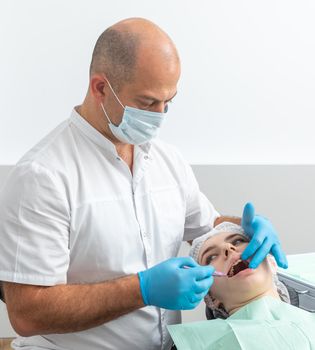Male dentist looks at a jaw of female patient. Showing the bite to the doctor