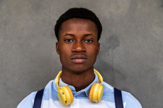 Teen African American male high school student looking at camera with serious expression. Back to school concept.