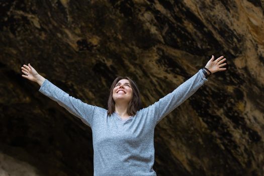 young girl learning rock climbing in high mountain with blue sweater, black tights and boots.