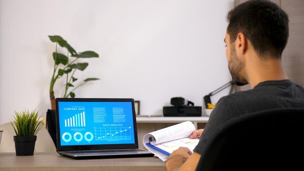 Business man working at office with laptop. Document on his desk. Motivated man