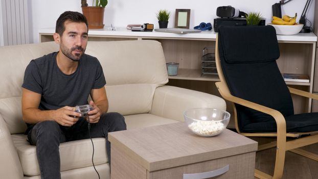 Young man playing video games at home. Elated man about his video games.