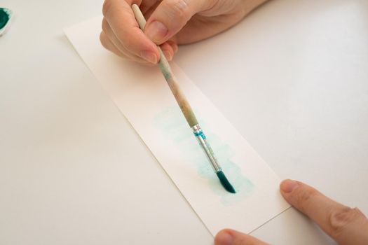 woman painting with watercolors in her studio at home