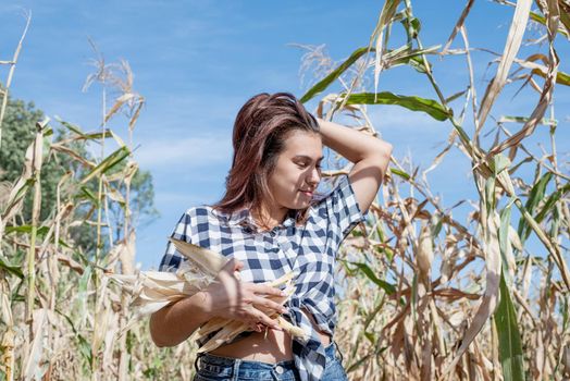 agriculture and cultivation concept. Countryside. Cheerful female caucasian woman in the corn crop