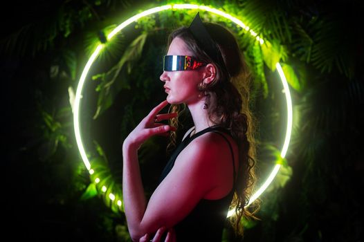 Caucasian woman in panoramic sunglasses against the background of an annular neon lamp in plants