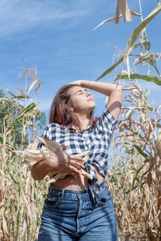 agriculture and cultivation concept. Countryside. Cheerful female caucasian woman in the corn crop