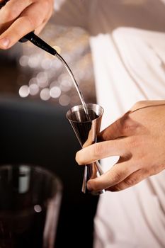 Closeup of bartender hands pouring alcoholic drink.Professional drink making