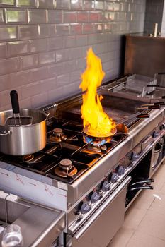 Chef making flambe fois gras in restaurant kitchen