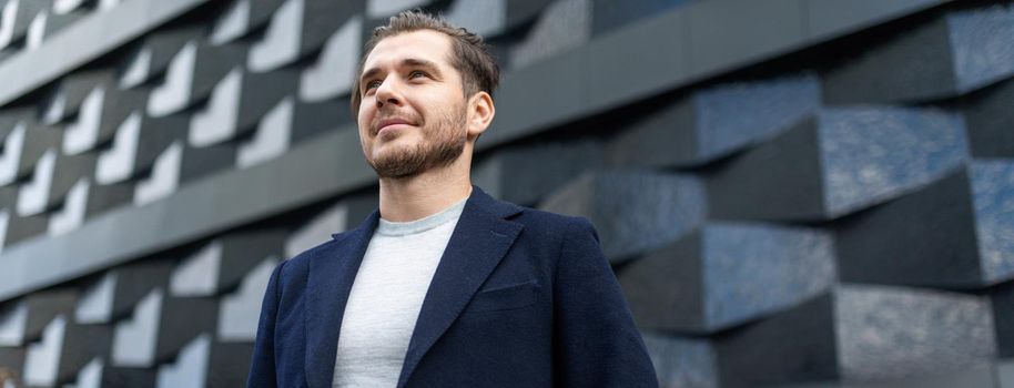 close-up portrait of a serious businessman against the background of the texture wall of the building.