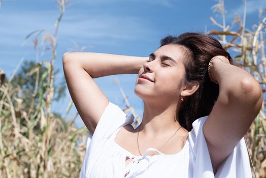 agriculture and cultivation concept. Countryside. Cheerful caucasian woman in white dress in the corn crop, sky background