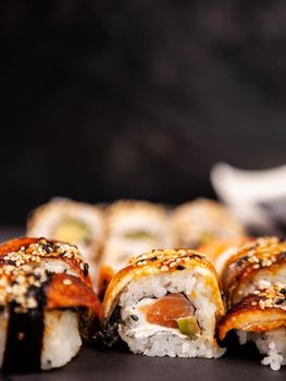 Mix variety of sushi rolls on black stone backgorund in studio
