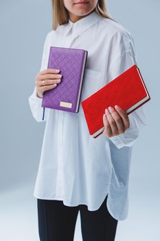 A stylish woman holds a notebook in her hands. Notebook for business records.