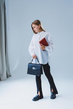Black classic leather bag in a girl's hand. Woman with luxury bag.