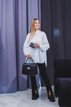 Black classic leather bag in a girl's hand. Woman with luxury bag.